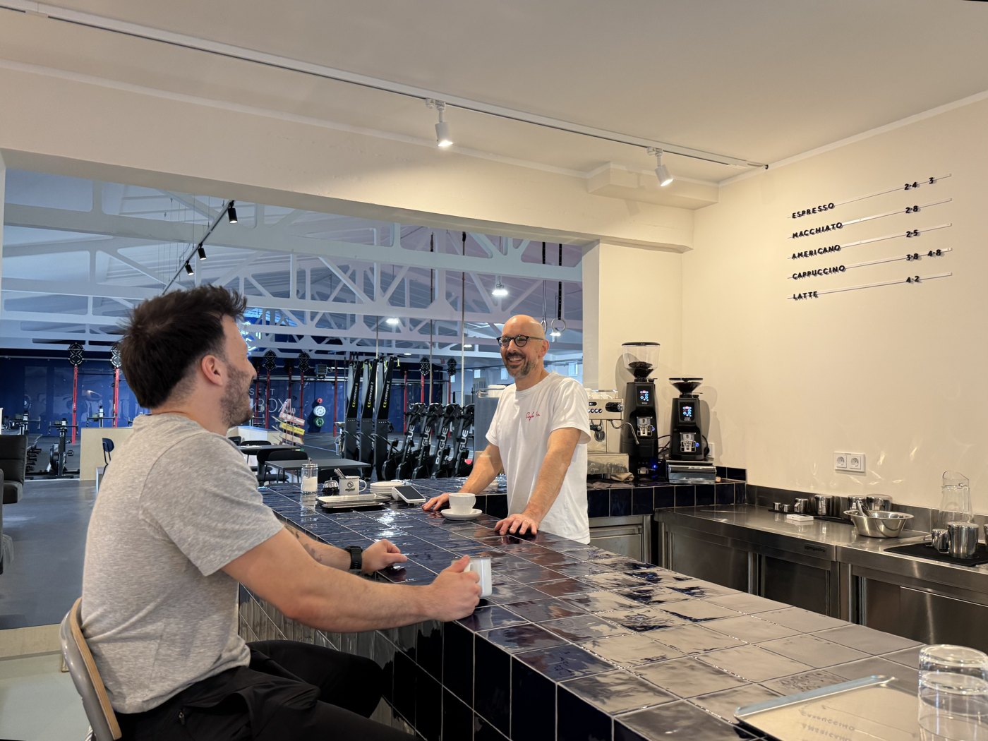 Chris und Berkin an der Kaffeemaschine im Café der CrossFit MainBox